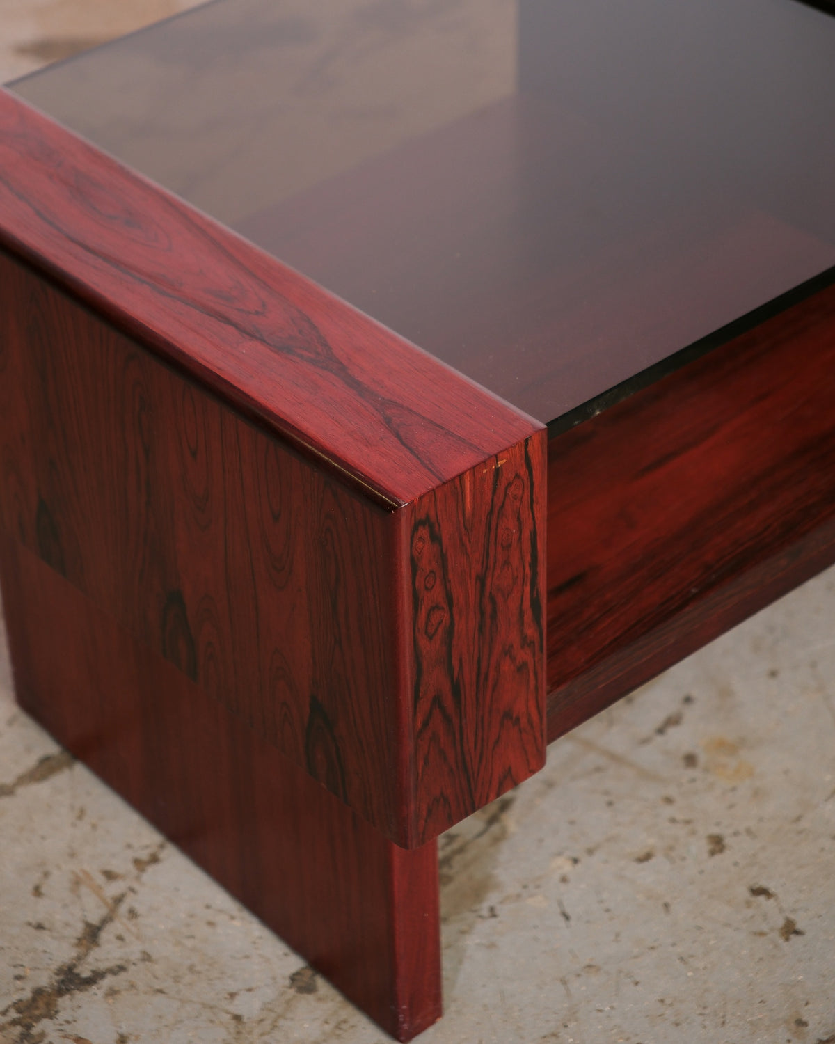 Close-up of the rosewood corner joinery and smoked glass top on the coffee table.