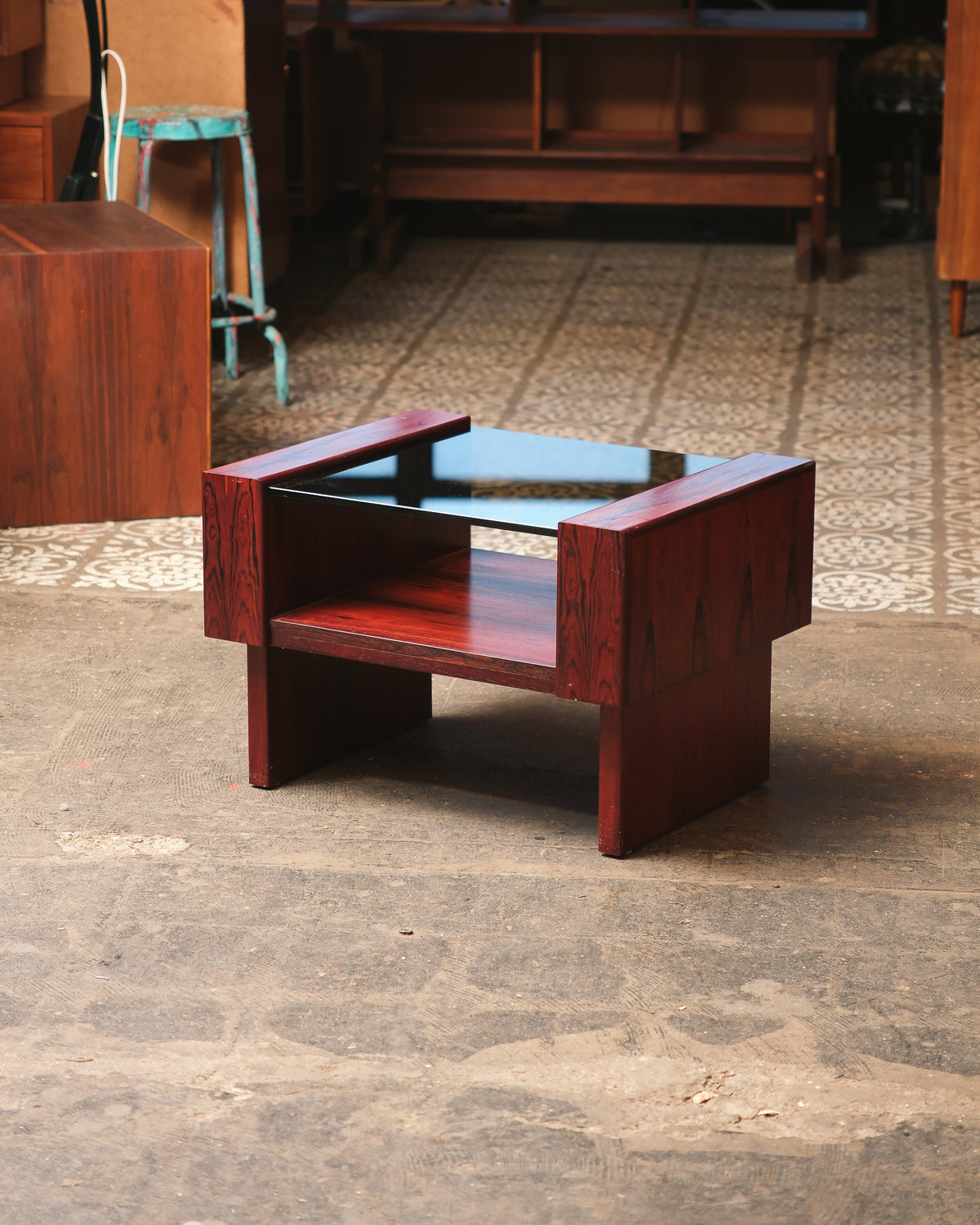 Angled view of the mid-century modern rosewood coffee table in a showroom setting.