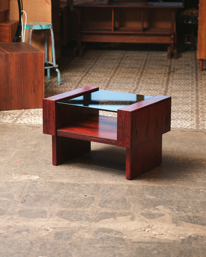 Angled view of the mid-century modern rosewood coffee table in a showroom setting.