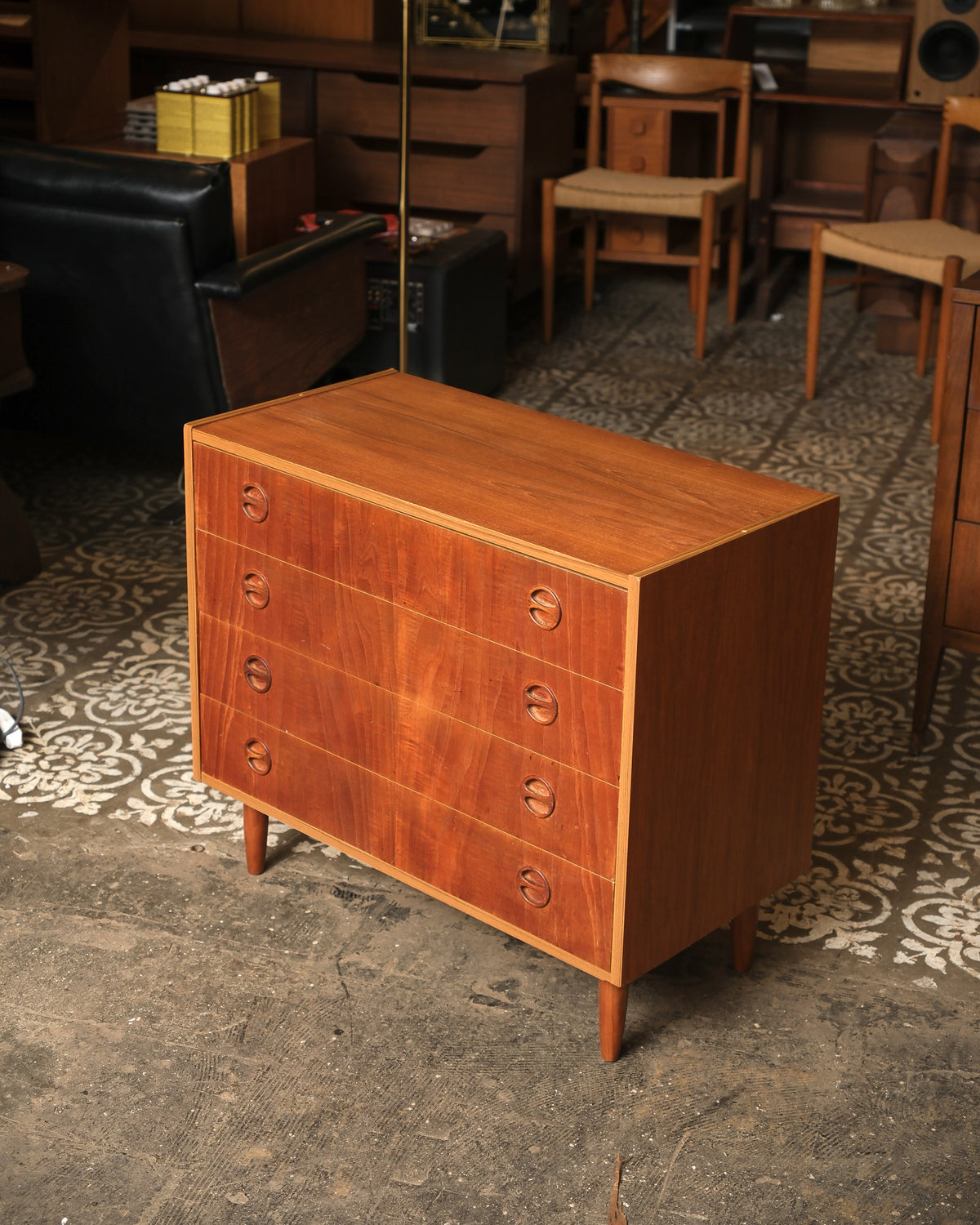 Angled view of the teak dresser showing top surface grain and drawer fronts.