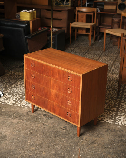 Angled view of the teak dresser showing top surface grain and drawer fronts.