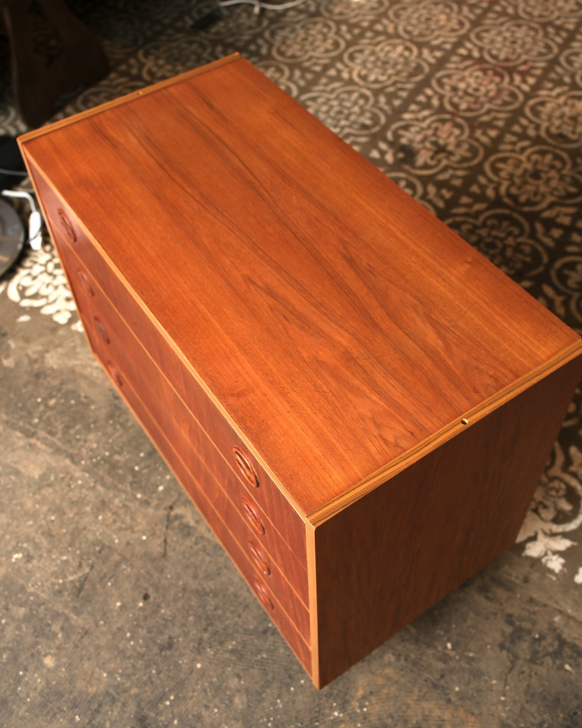 Overhead angled view showing the top and side of the teak dresser.