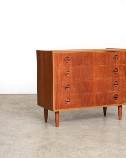 Close-up angle of the dresser's front left corner showing tapered legs and pulls.