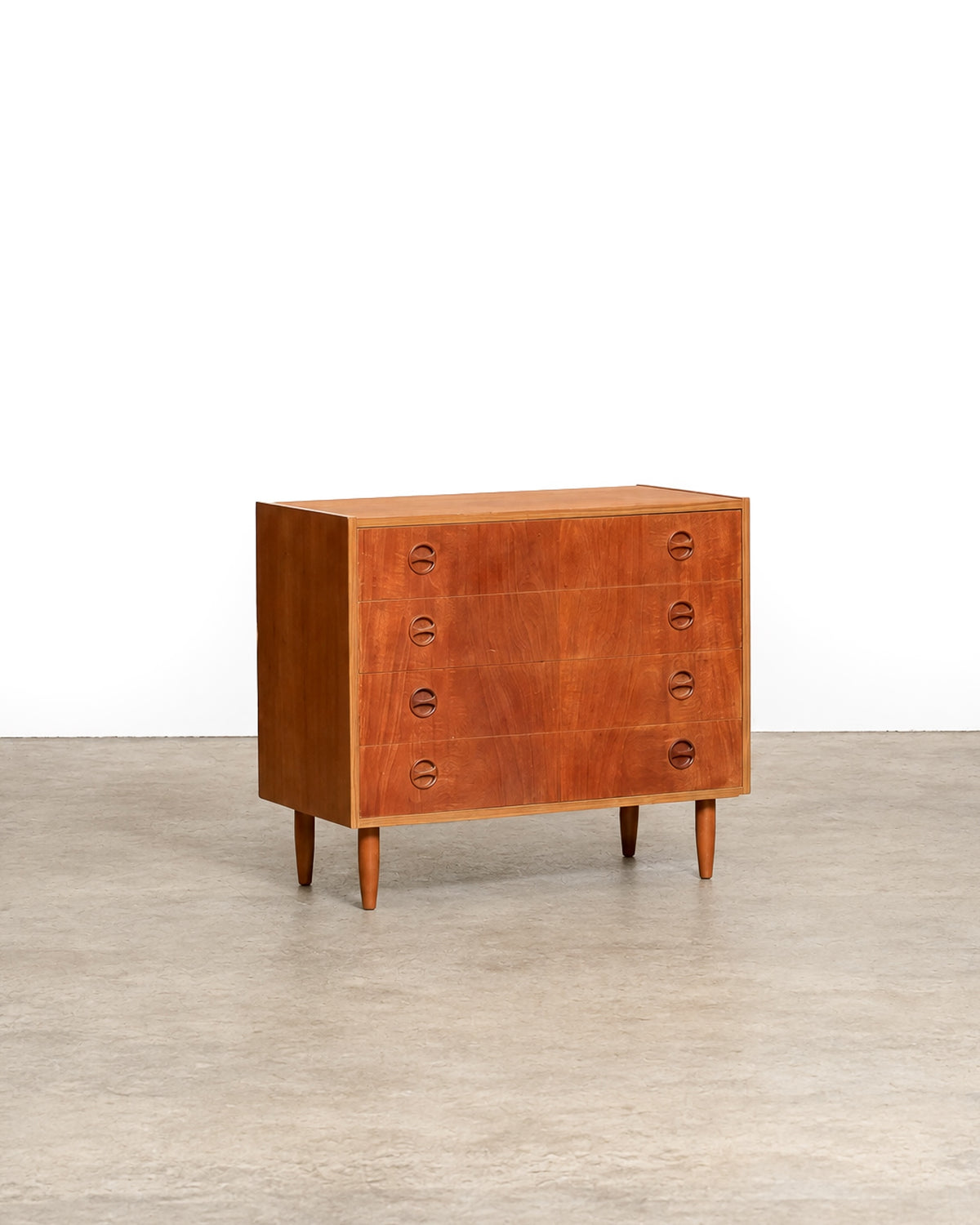 Studio shot of the teak dresser against a white background, angled front view.