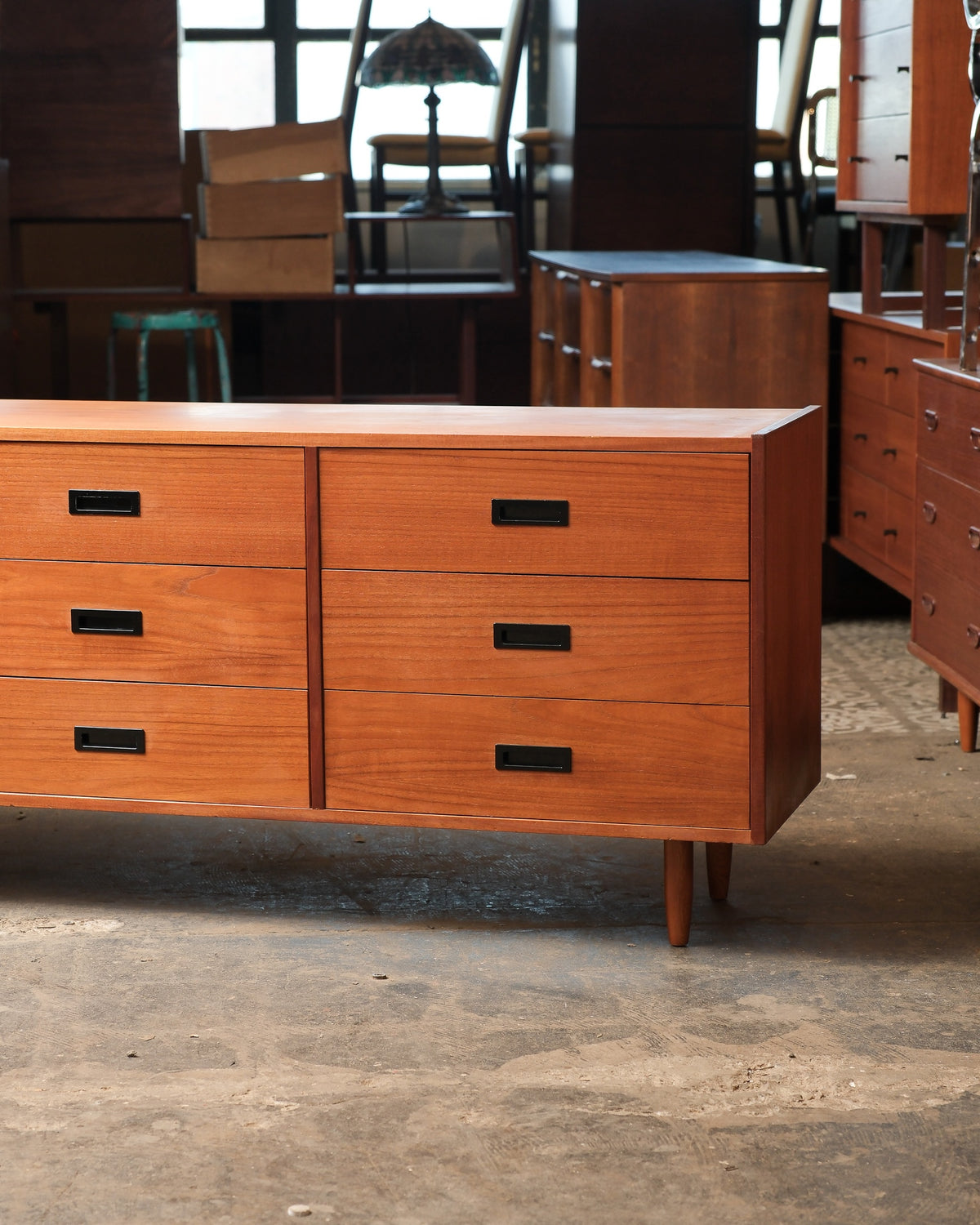 Close-up of the right side drawer bank showing pulls, grain, and tapered leg