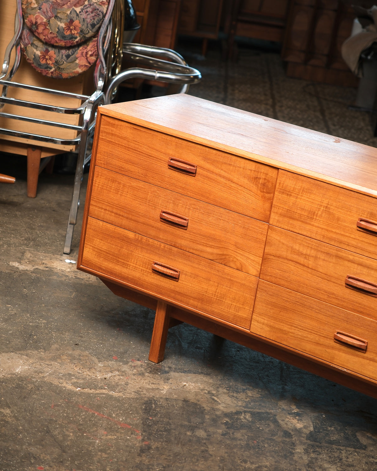 Angled side view of the teak dresser highlighting the grain pattern and drawer joinery.