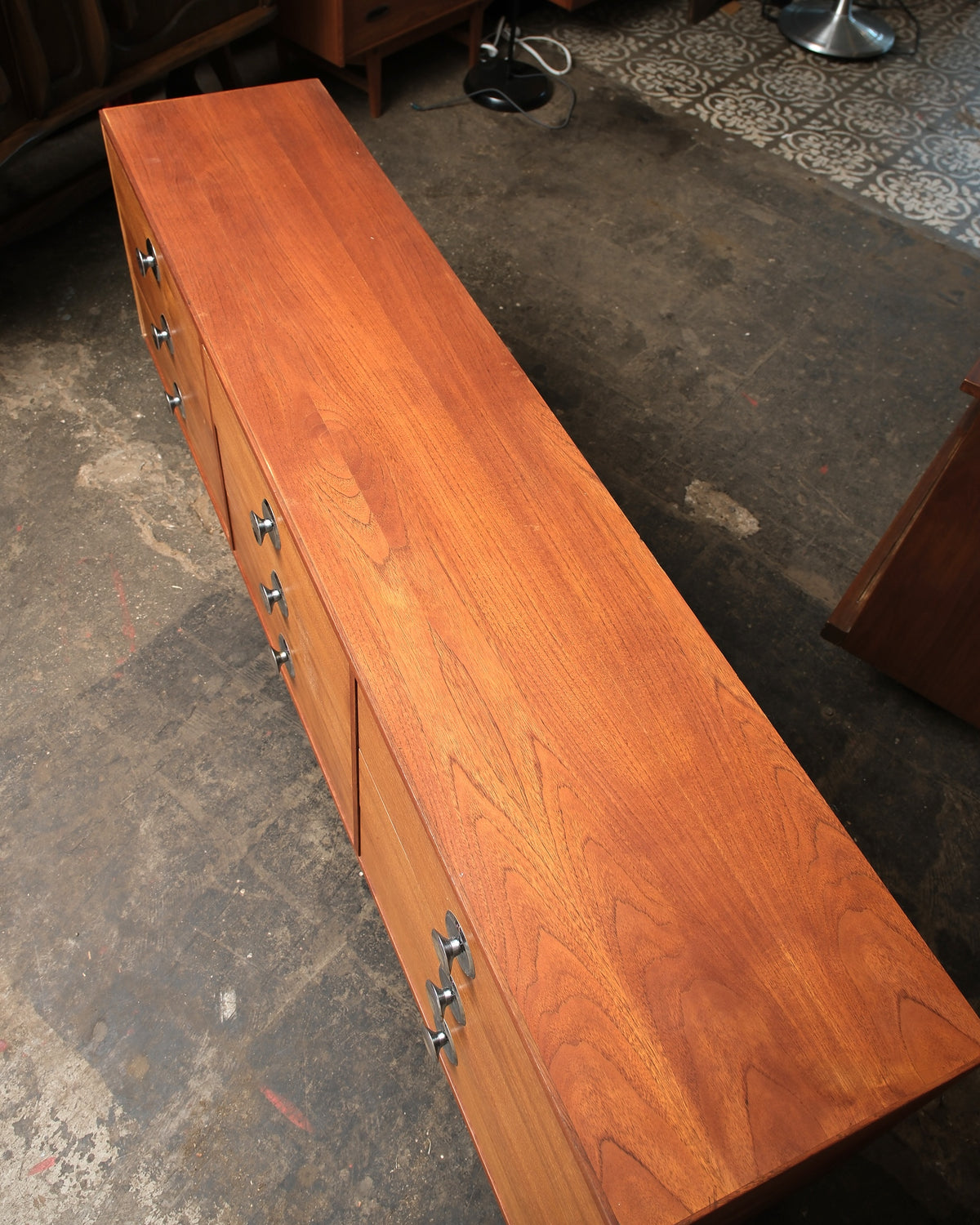 Overhead view of the dresser showing the teak top grain and drawer layout with a lower cabinet door.