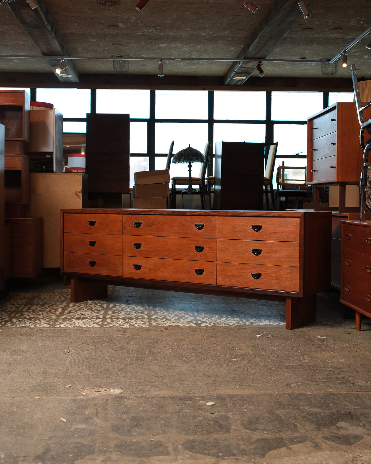 Full front view of the teak dresser showing all nine drawers and block legs.