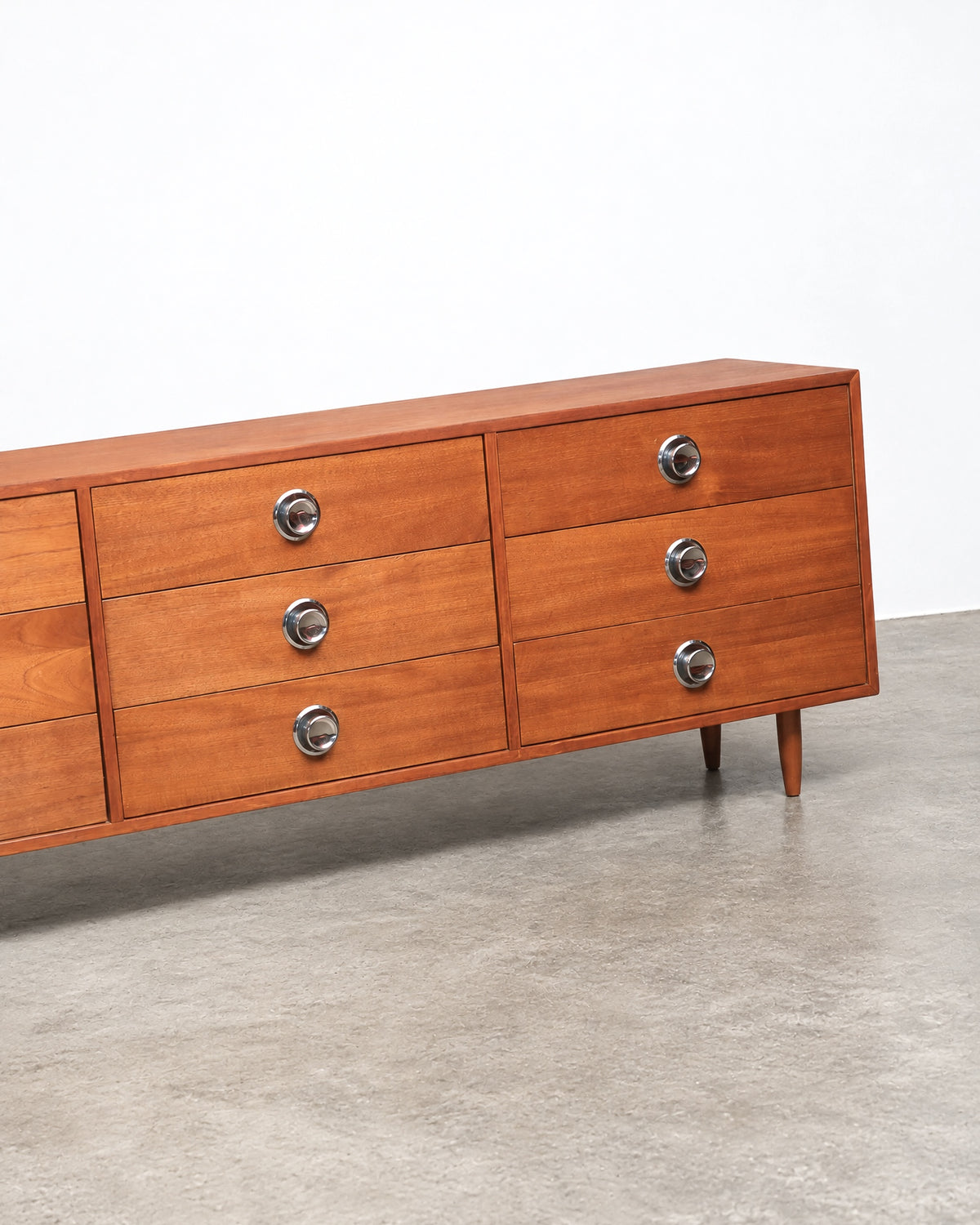Additional angle of the teak dresser showing the case construction and drawer alignment.
