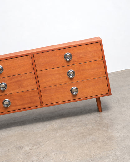 Detail view of the dresser's lower cabinet door and chrome pulls.