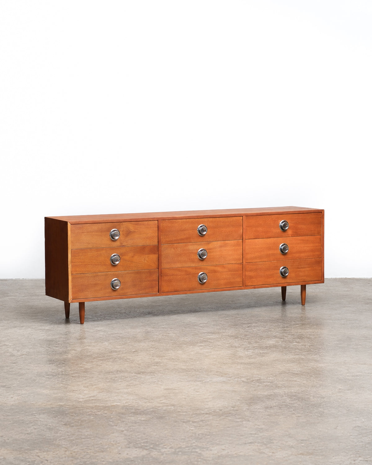 Full view of the teak 9-drawer dresser from a slight distance, showing overall proportions.