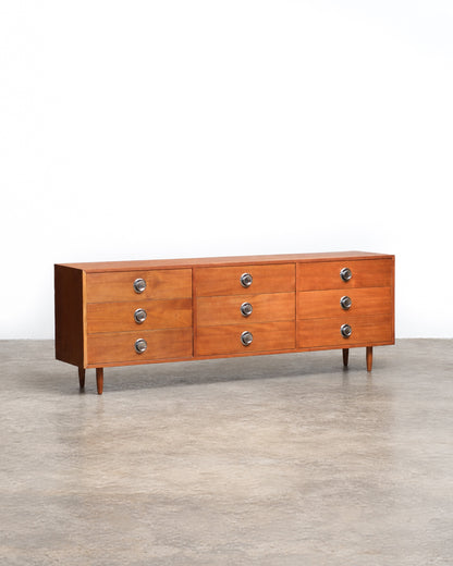 Full view of the teak 9-drawer dresser from a slight distance, showing overall proportions.