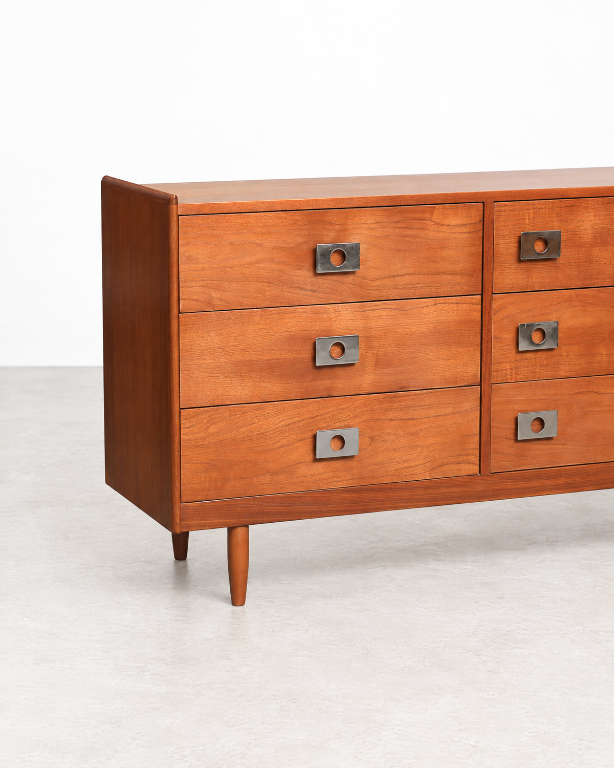 Close-up of a tapered leg and the base of the dresser.