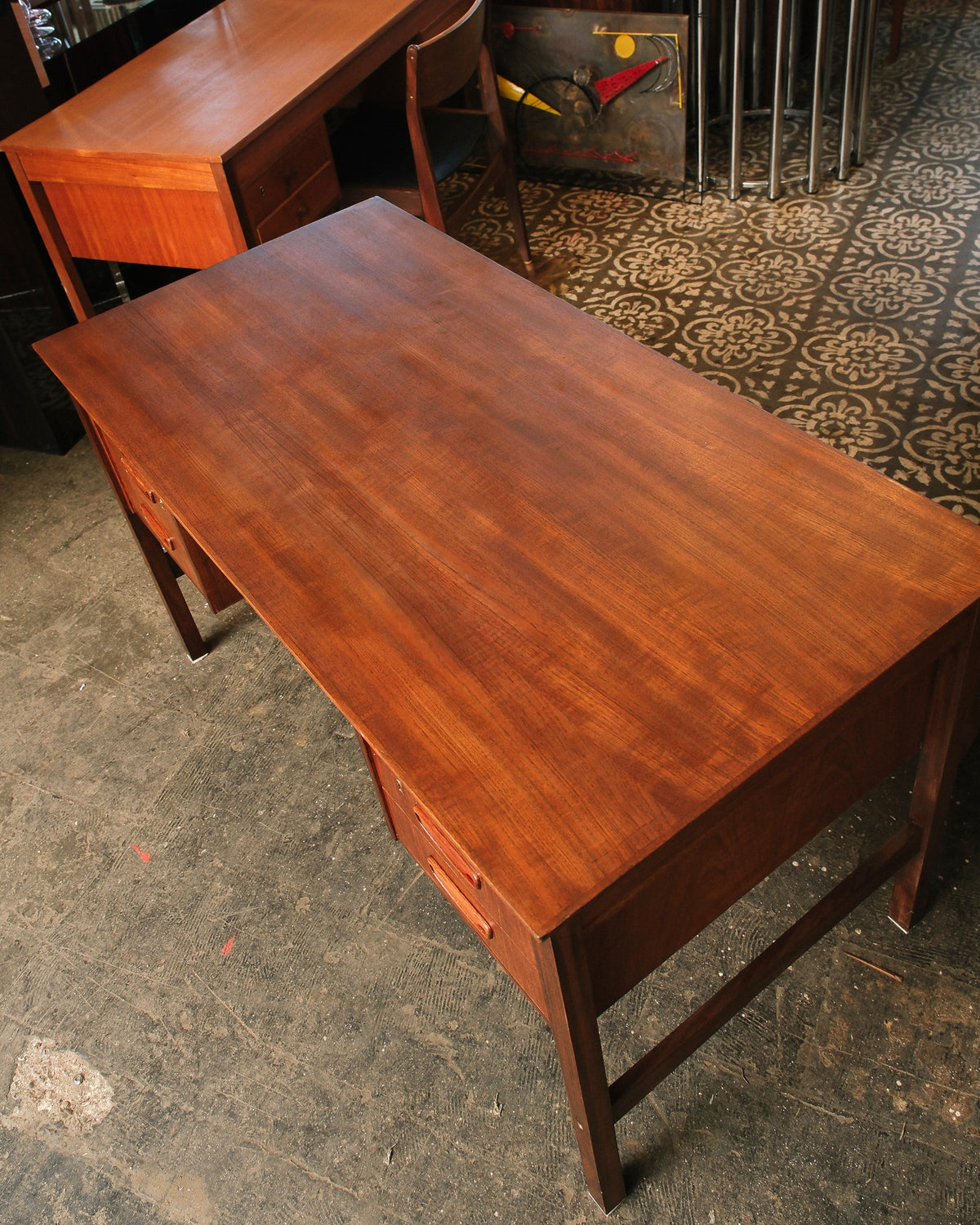 Overhead angled view of the teak desk top showing the natural grain and drawer pulls.