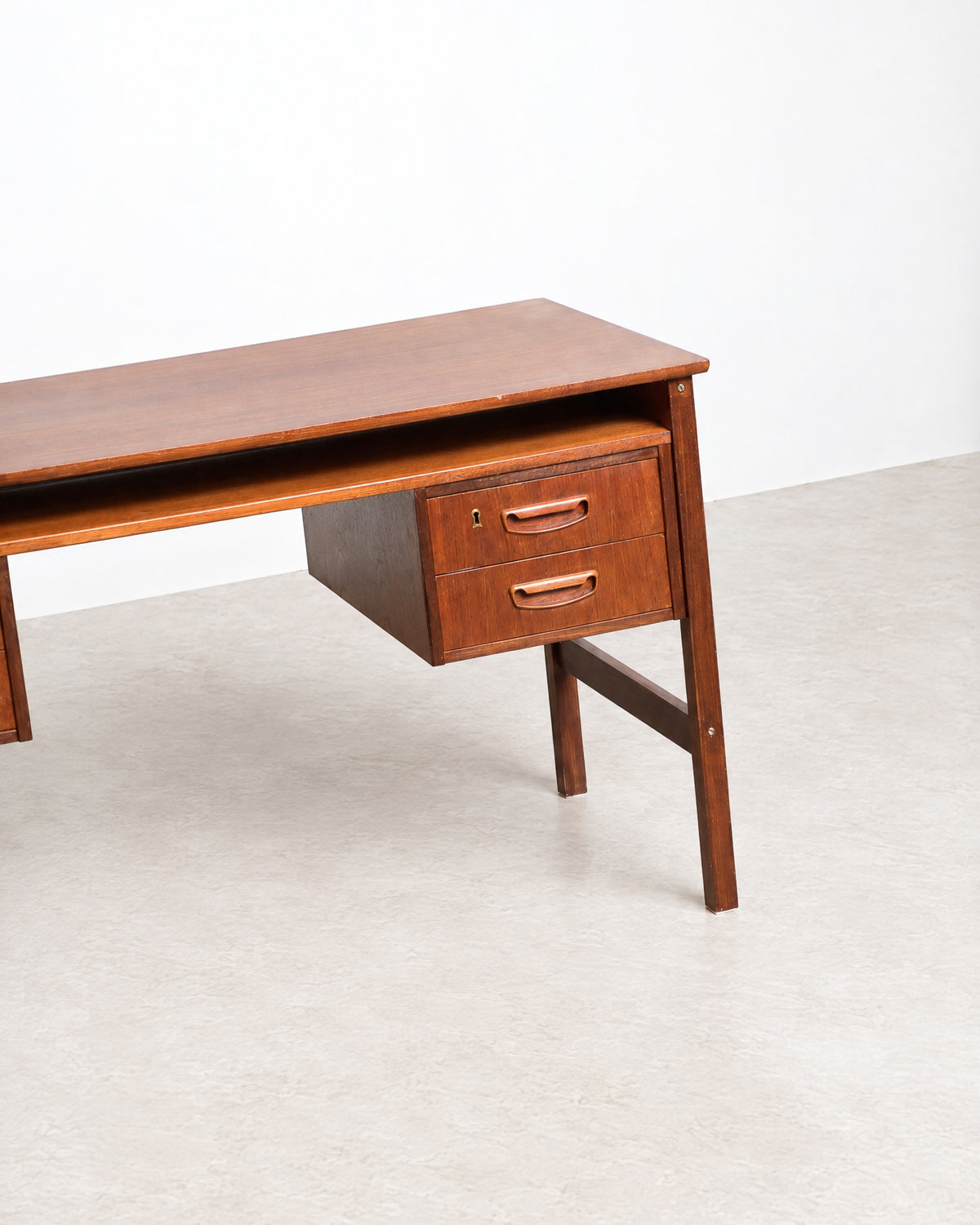 Close-up of one drawer pedestal and the angled leg, showing joinery and finish.