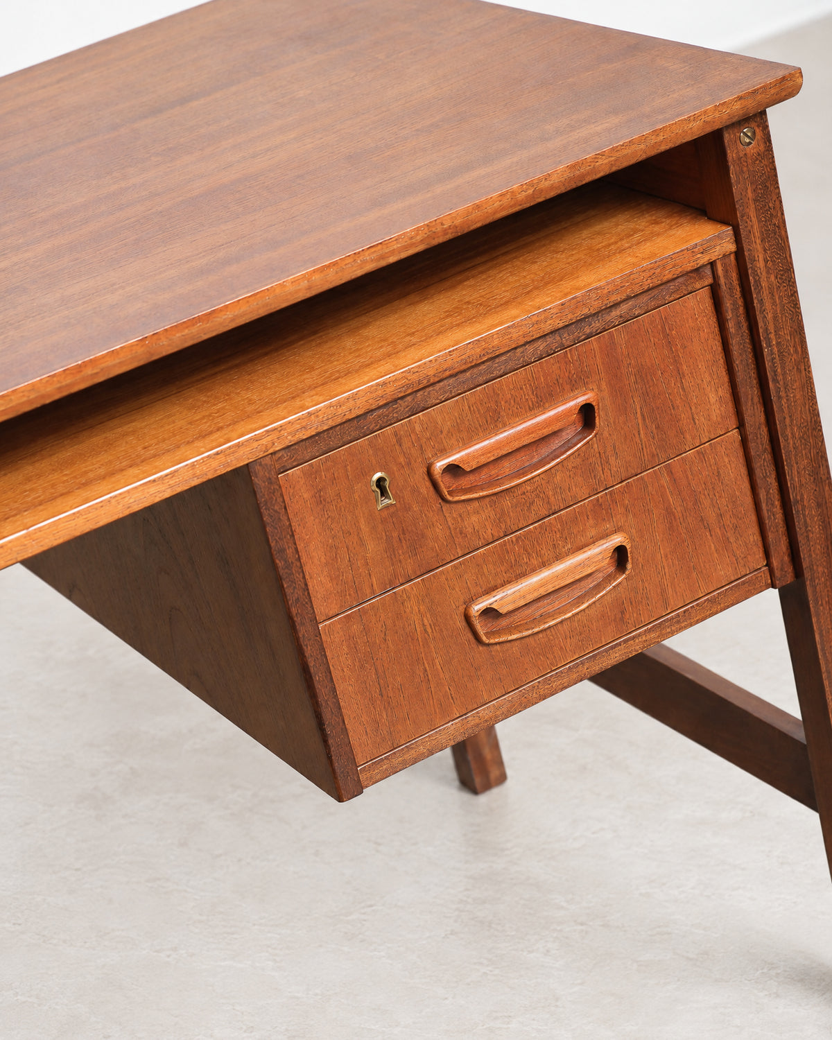 Additional angle of the teak desk highlighting the top surface and grain pattern.