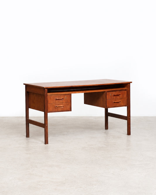 Rear or side angle of the teak desk showing overall construction and leg bracing.