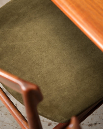Overhead close-up of olive velvet chair seat next to table edge