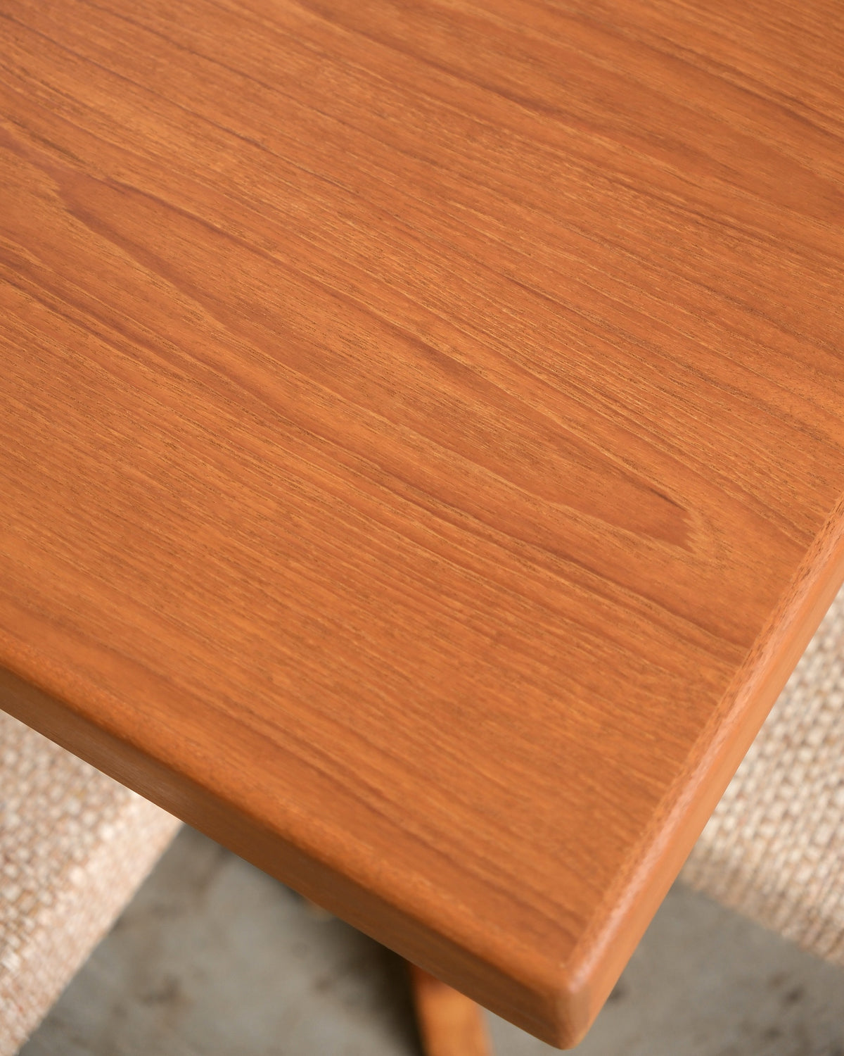 Close-up of the table's corner edge showing teak grain and finish