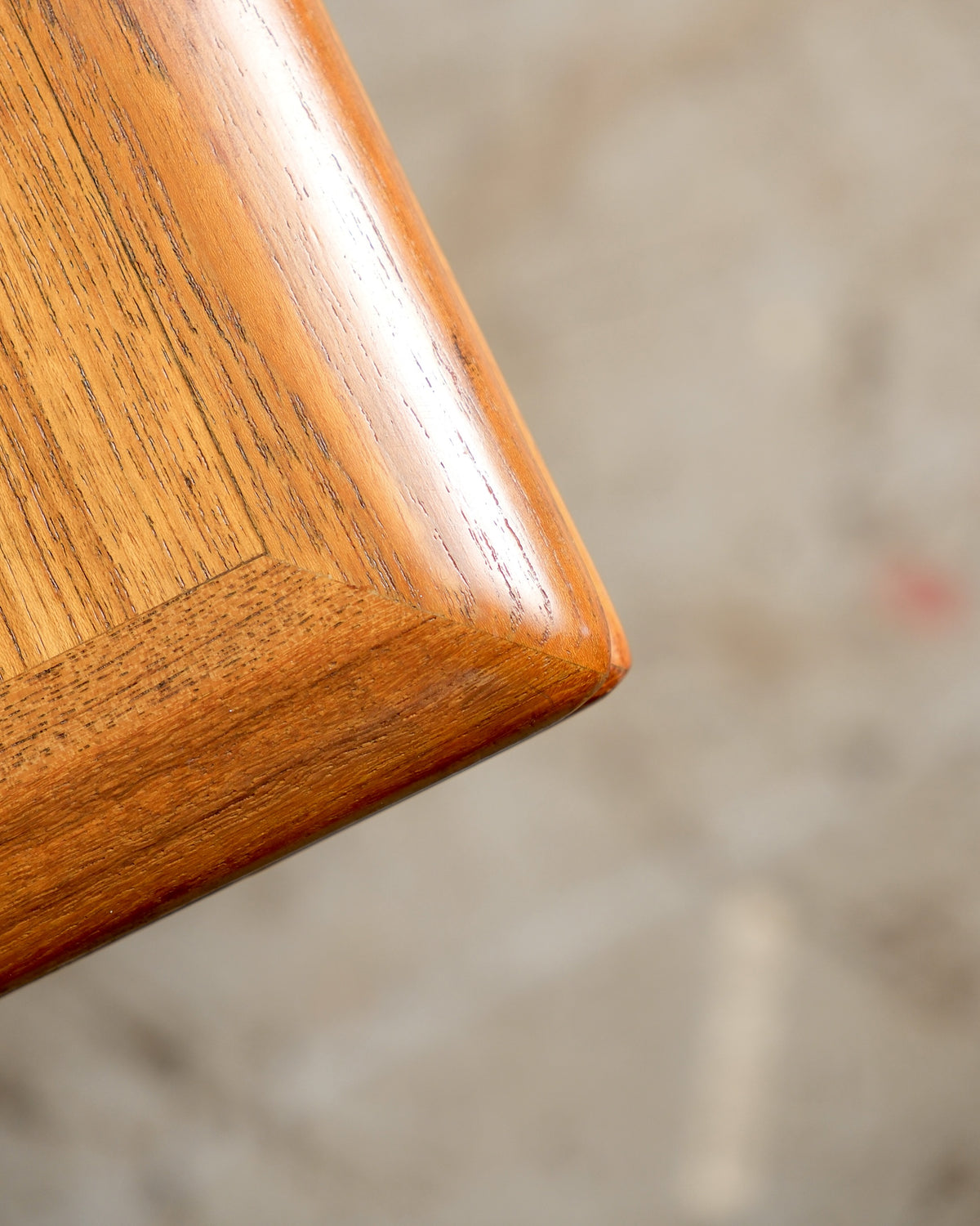 Close-up of the teak tabletop corner showing grain detail and rounded edge finish.