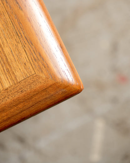 Close-up of the teak tabletop corner showing grain detail and rounded edge finish.