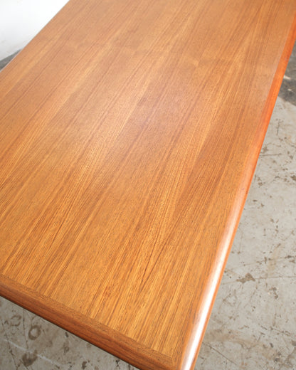 Angled view of the teak tabletop surface highlighting the natural wood grain pattern.