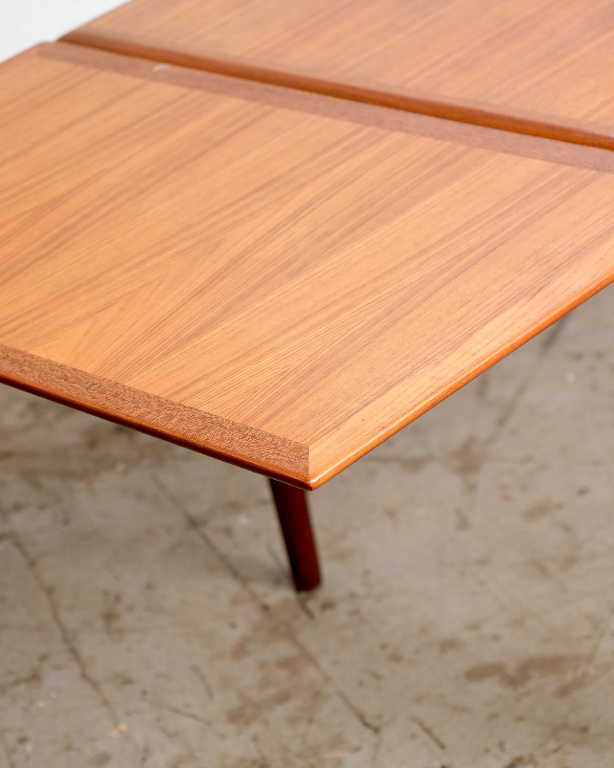 Close-up of the extension leaf seam where the table opens to accommodate the leaf.