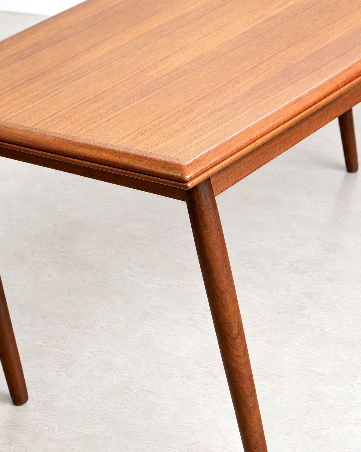 Close-up of a tapered leg and tabletop edge showing joinery and finish detail.