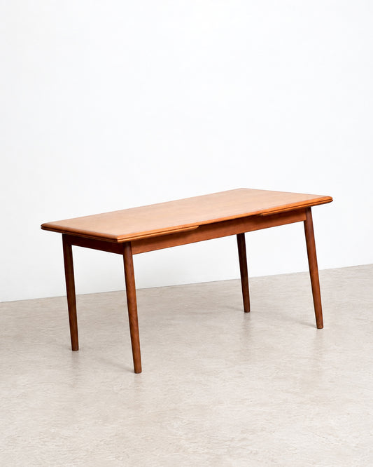 Side view of the teak dining table in its closed, standard-length position.