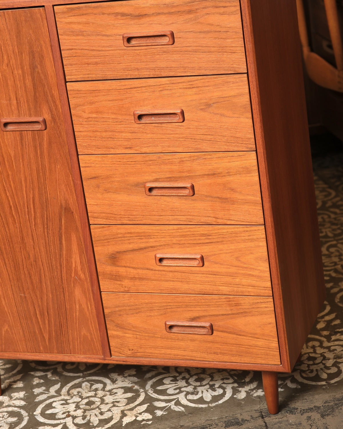 Close-up of the carved sculpted drawer pulls and teak grain on the gentleman's chest.