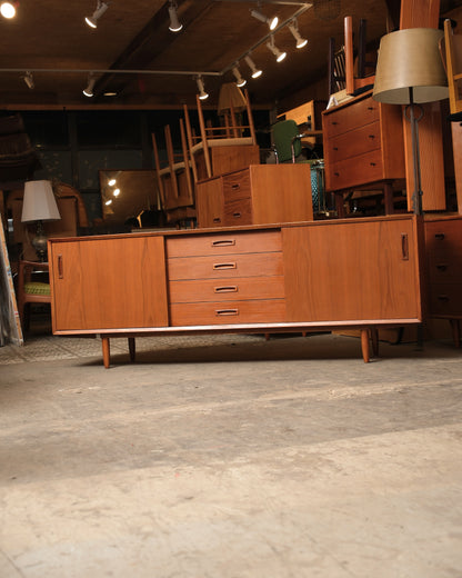 Front view of the teak sideboard with four central drawers and sliding doors