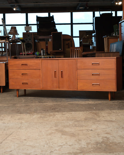 Straight-on view of the teak sideboard highlighting symmetrical drawer banks and recessed pulls.