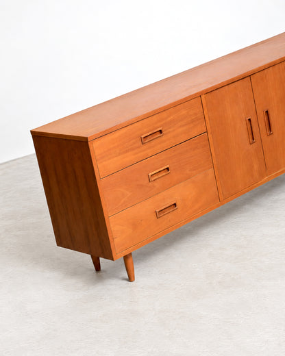 Side angle view of the teak sideboard showing depth and tapered leg detail.