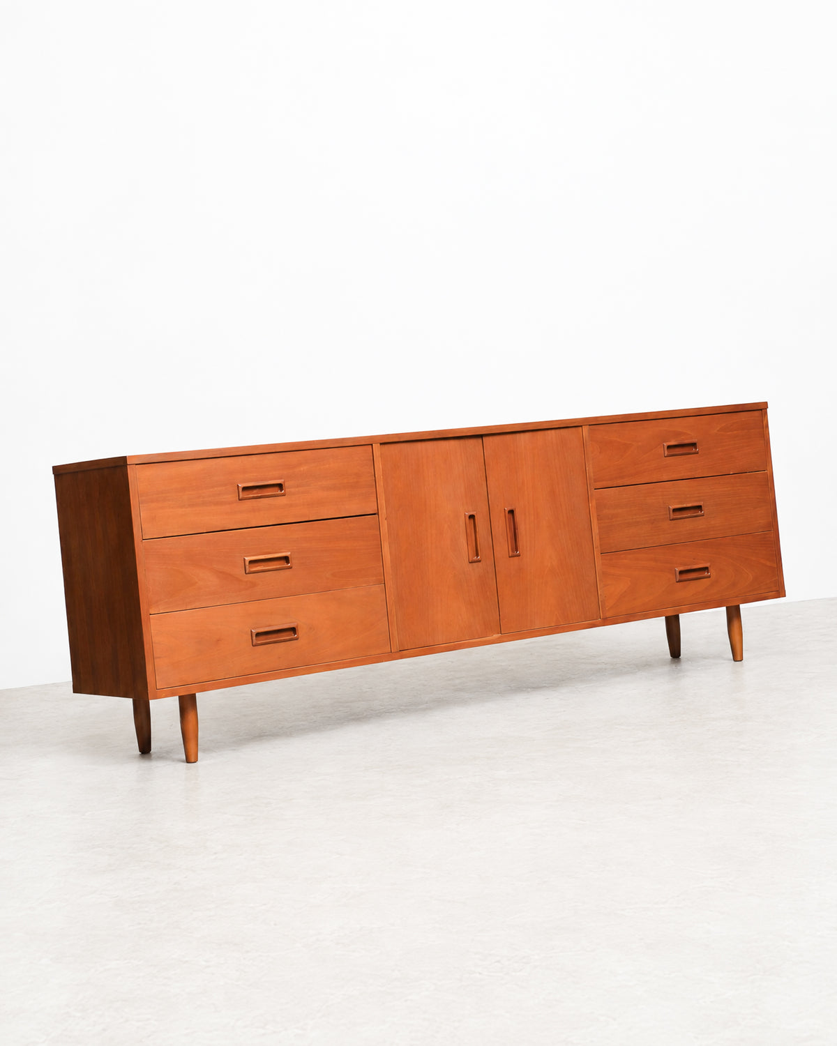 View of the sideboard's cabinet doors closed, showing door pulls and grain pattern.