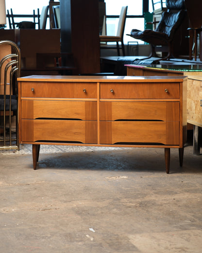 Front view of the mid-century modern walnut 6-drawer dresser on tapered legs.