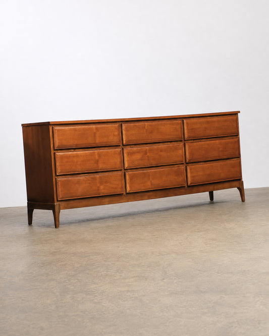 Angled side view of the dresser on a plain background showing its full profile and tapered legs.