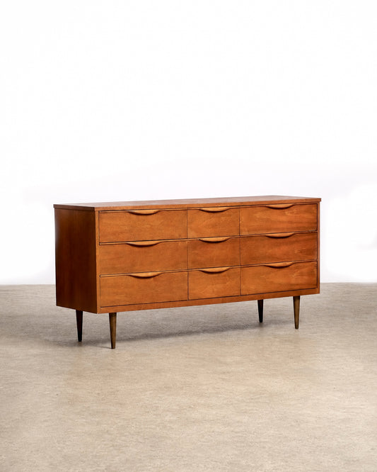 Full view of the walnut 9-drawer dresser in a showroom setting.
