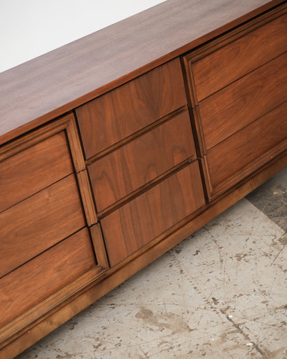 Close-up angle of the walnut dresser showing the raised center drawer panel and grain detail.