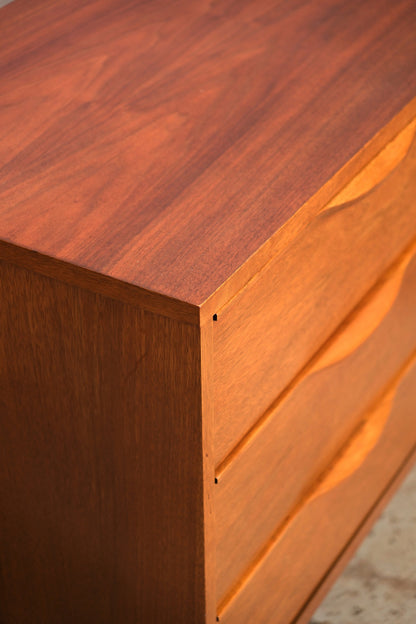 Detail of the top corner joinery and drawer pulls on a walnut mid-century dresser.
