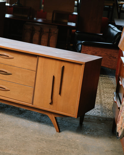 Close-up of side and drawer handles showing sculpted pull design and tapered leg.