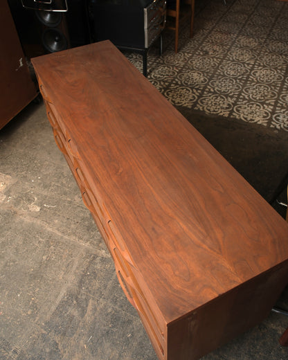 Overhead view of the dresser top showing the walnut grain pattern and surrounding room