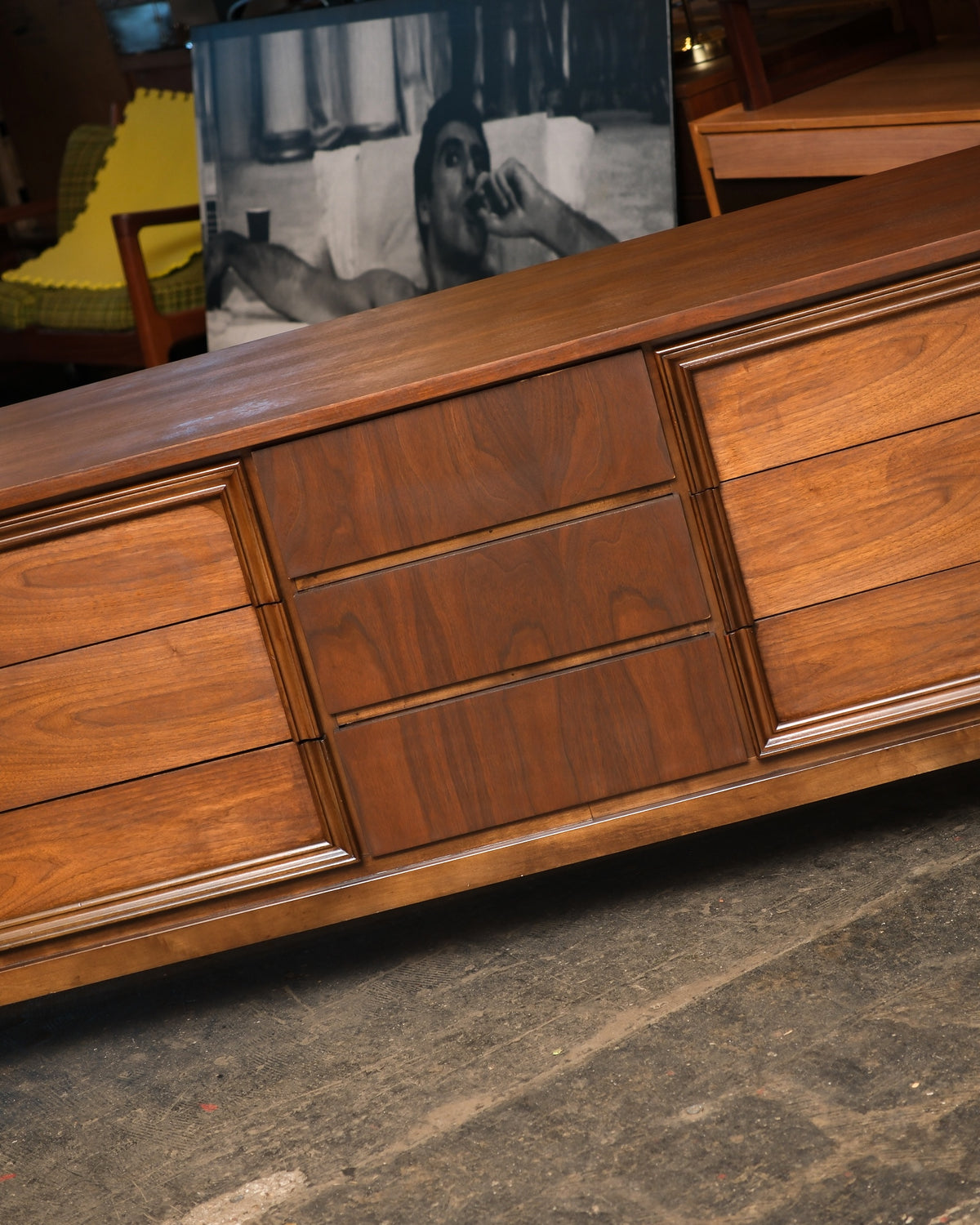 Angled view of the dresser top and center drawer detail with surrounding vintage furniture visible.