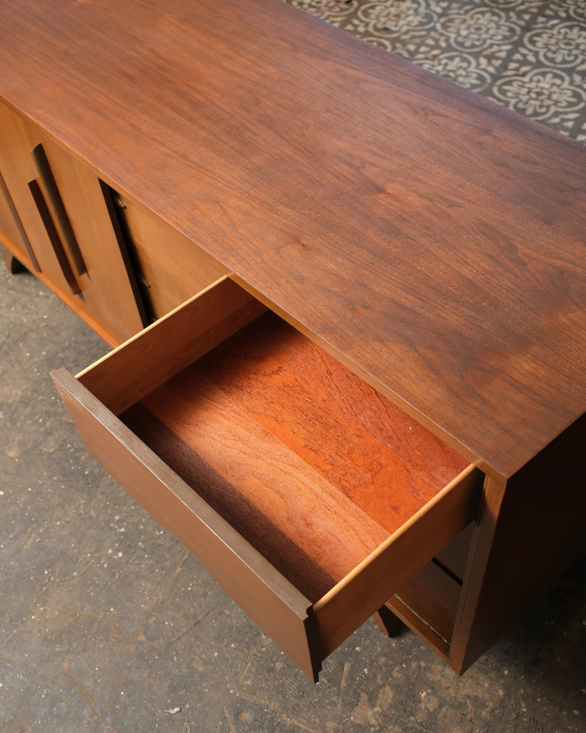 Overhead view of one open drawer showing interior wood construction and grain.