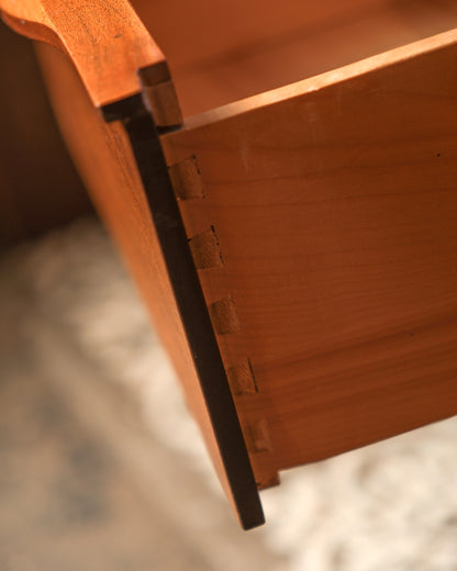 Three-quarter view of the dresser highlighting its tapered legs and low profile.