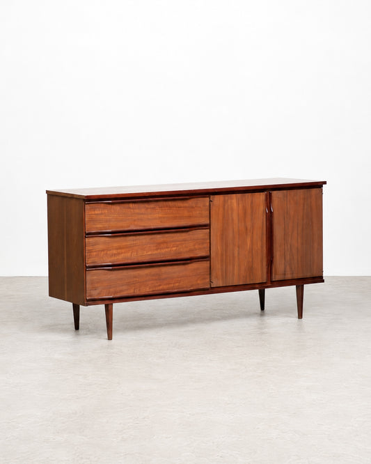 Full view of the credenza shown in the shop among other vintage furniture