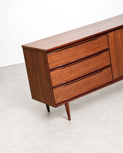 Detail of the sculpted drawer pulls and tapered leg on the credenza's corner