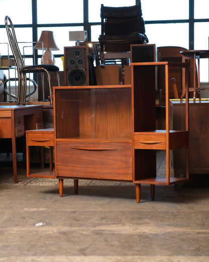 Front view of the walnut display cabinet showing the glass sliding door, lower drawer, and side open shelves with drawers.