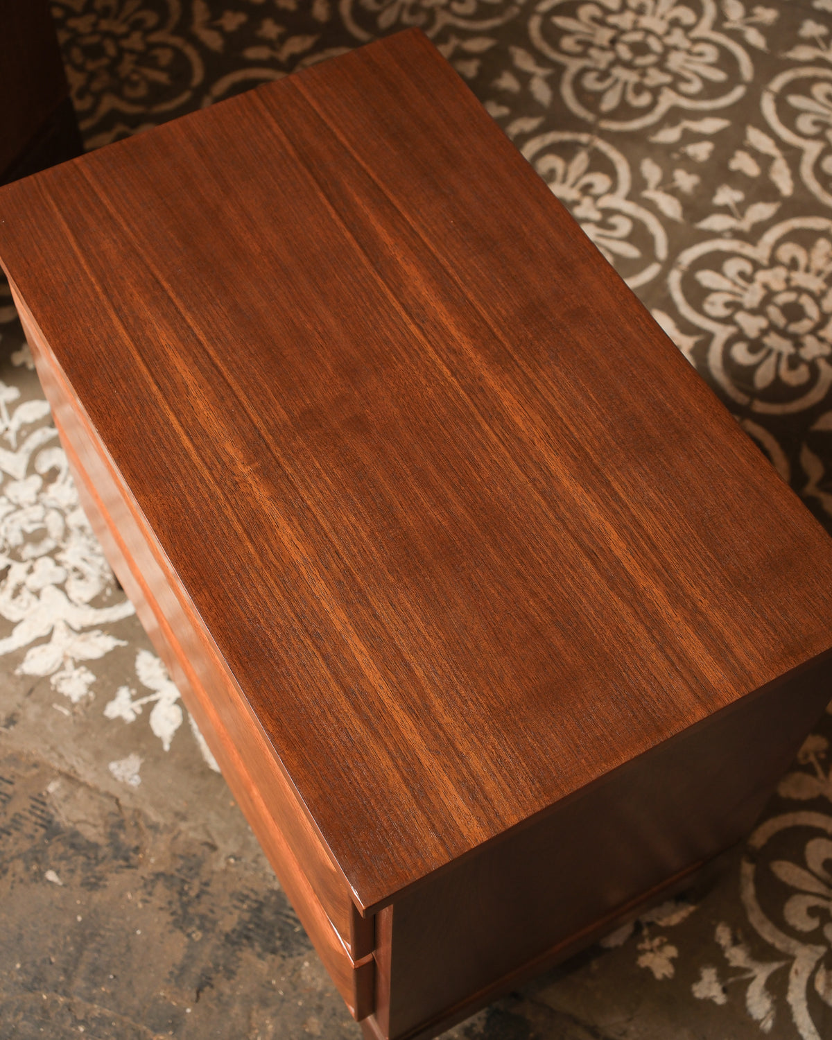 Close-up overhead view of the nightstand top showing natural walnut wood grain.