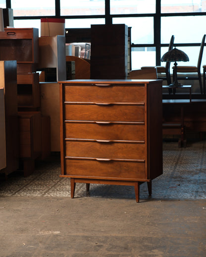 Front view of the walnut tallboy dresser showing tapered legs and natural wood grain.