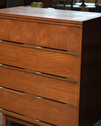 Close-up of the top drawer's book-matched walnut grain and recessed pull.